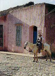 Horse and rider outside a Cuban house